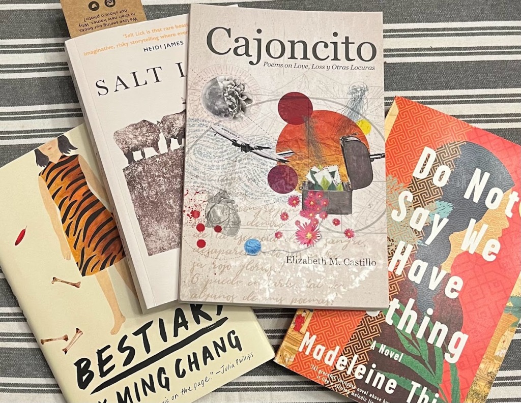 Photo (by Rita E. Gould) of 4 books on a grey and white striped background. The books are The Salt Lick by Lulu Allsion, Cajoncito by Elizabeth M. Castillo, Do Not Say We Have Nothing by Madeleine Thien, and Bestiary by K-Ming Chang.